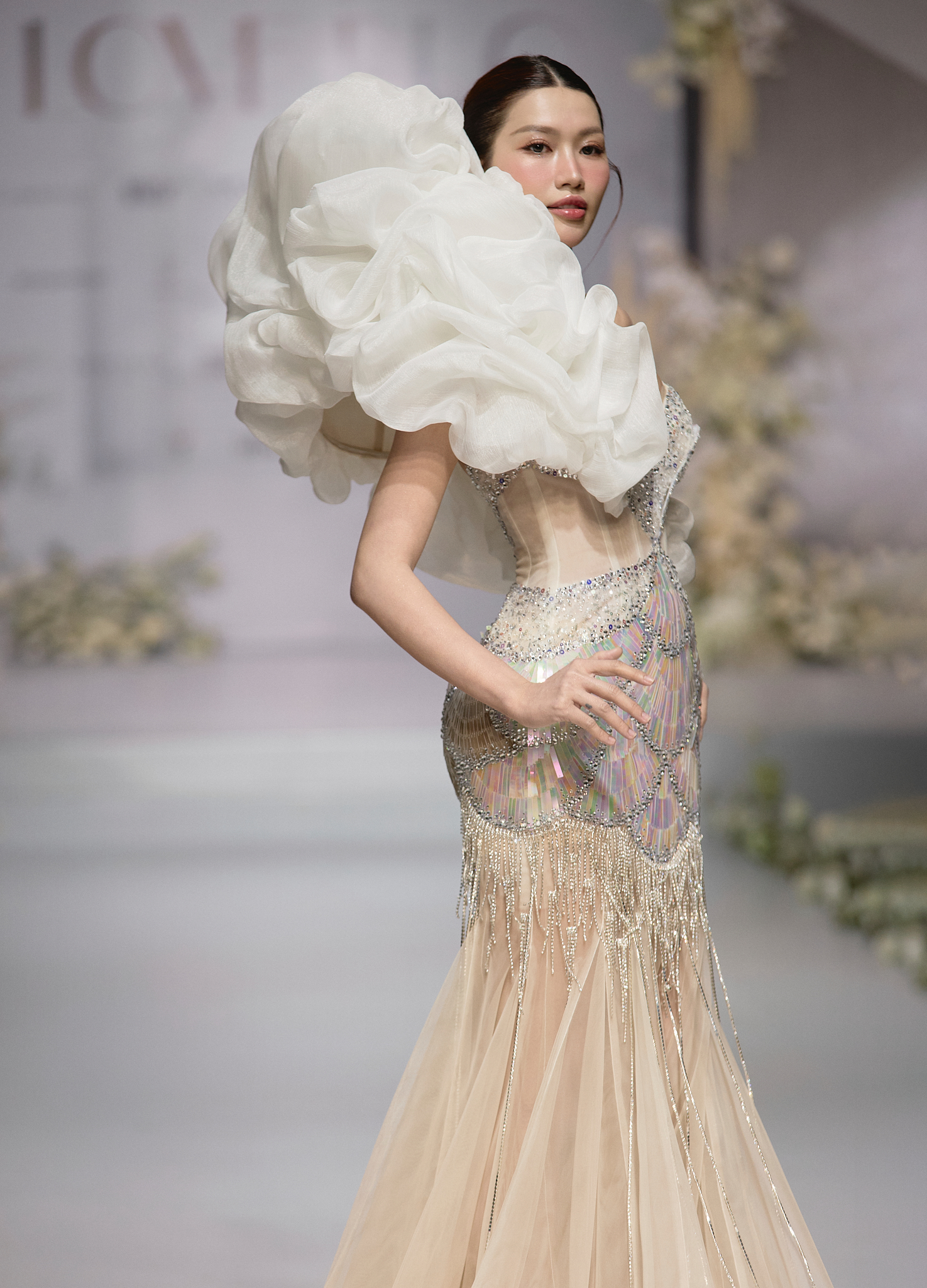 Mở màn bộ sưu tập, Á hậu Chế Nguyễn Quỳnh Châu giữ vai trò First Face với thiết kế ôm sát tôn vòng 1 và đường cong, những dải organza được xếp thành đường uốn lượn độc đáo, tạo nên sự quyến rũ, ấn tượng.