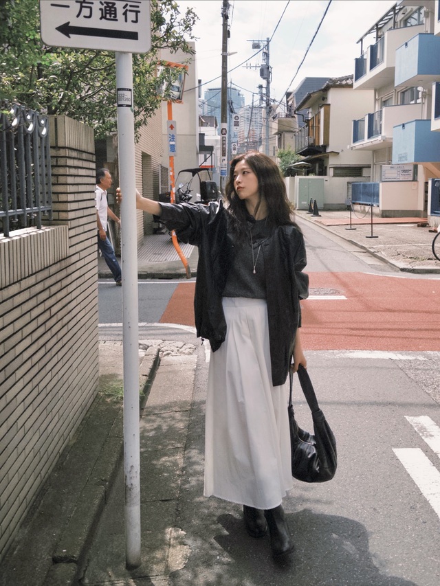  Áo len trơn, khoác ngoài áo da cùng chân váy chữ A trắng mang đến vẻ năng động nhưng vẫn giữ được nét nữ tính.