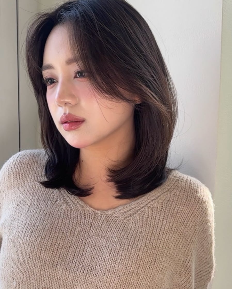 Với những ai yêu thích vẻ ngoài mềm mại và nữ tính, tóc ngang vai cùng mái uốn nhẹ là lựa chọn đáng cân nhắc. 