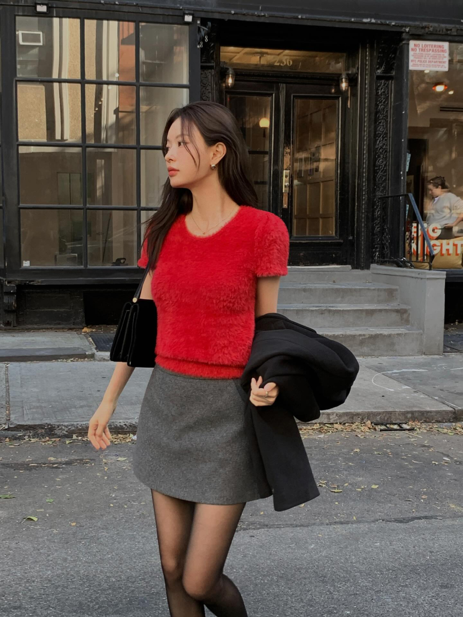 Màu đỏ luôn gợi nhắc đến không khí rộn ràng và nguồn năng lượng tích cực của mùa lễ hội. Khi kết hợp áo đỏ với chân váy ngắn,