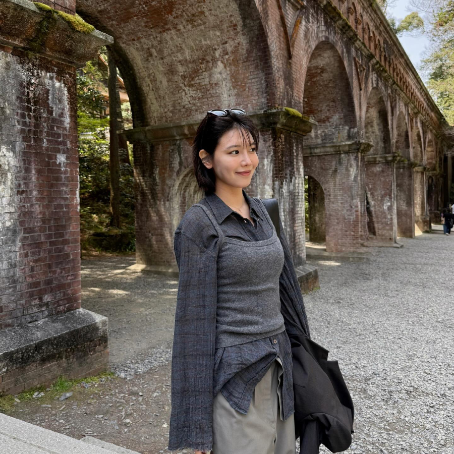 Bộ trang phục layer gồm áo sơ mi kẻ, áo hai dây len và quần kaki tạo cảm giác phóng khoáng.